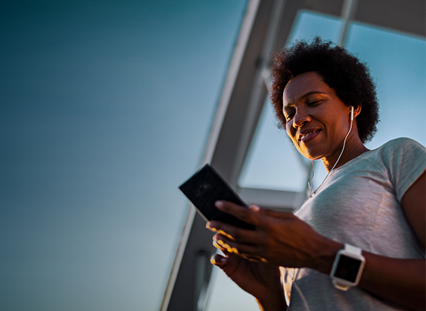 women holding phone listening to music